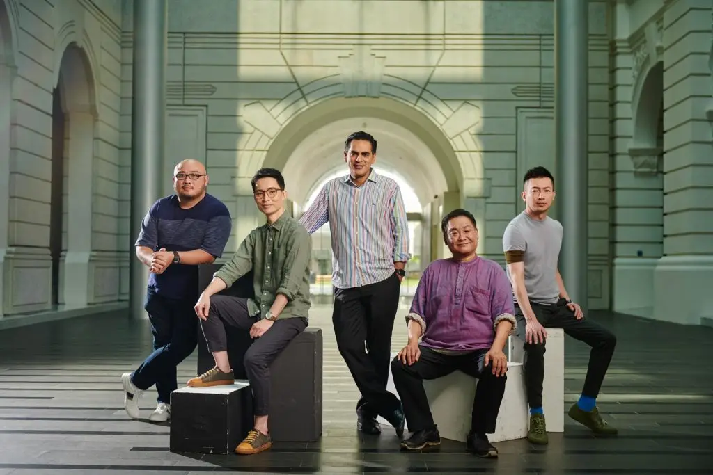 Five Singapore theatre directors in a relaxed group portrait in an industrial arched space — environmental portrait photographer singapore, on location corporate portrait singapore