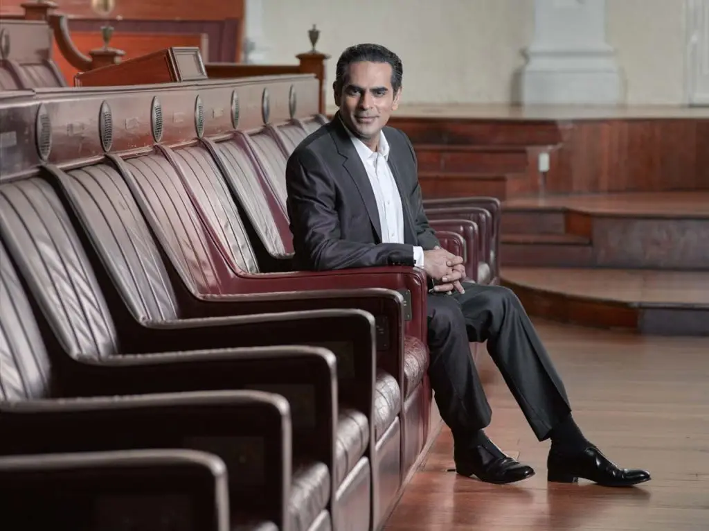 Gaurav Kripalani seated among the red chamber seats at the Old Parliament House — environmental portrait photographer singapore, on location corporate portrait singapore