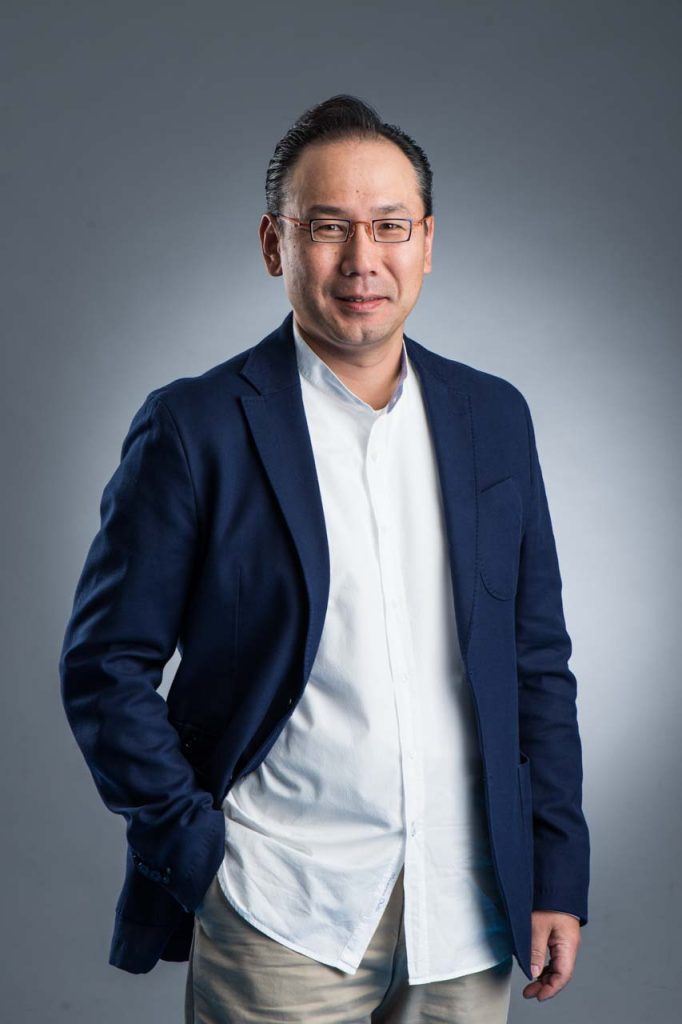 Professional executive headshot of a finance executive in a navy blazer over a white t-shirt, arms folded — singapore C-suite portrait photography
