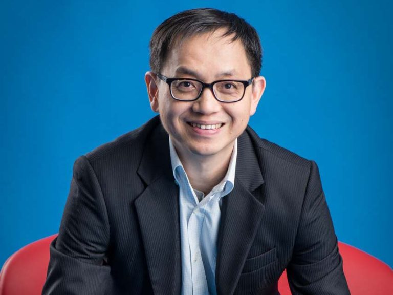 Smiling corporate portrait of eBay Greater China CEO John Lin wearing glasses