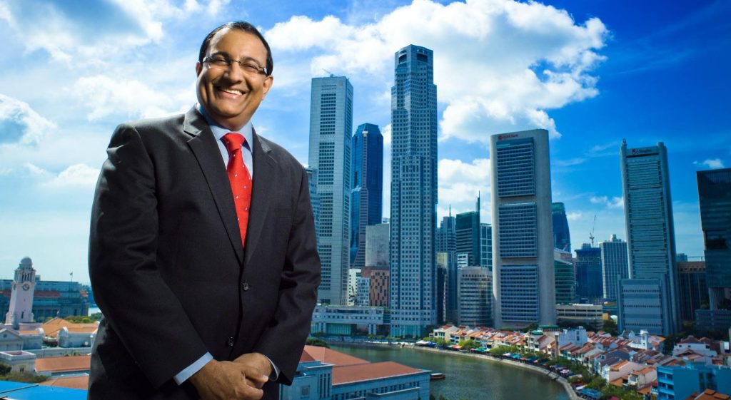 Singapore's Minister for Trade and Industry photographed on a rooftop against the Marina Bay and CBD skyline — singapore corporate portrait photography