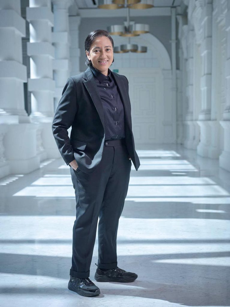 Natalie Hennedige walking through a bright colonnade at Victoria Theatre — singapore C-suite portrait photography, environmental portrait photographer singapore