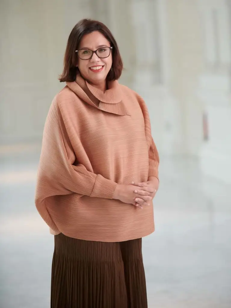 Sarah Martin, Chief Executive Officer of Arts House Limited, in a soft peach knit against a pale background — singapore C-suite portrait photography, environmental portr