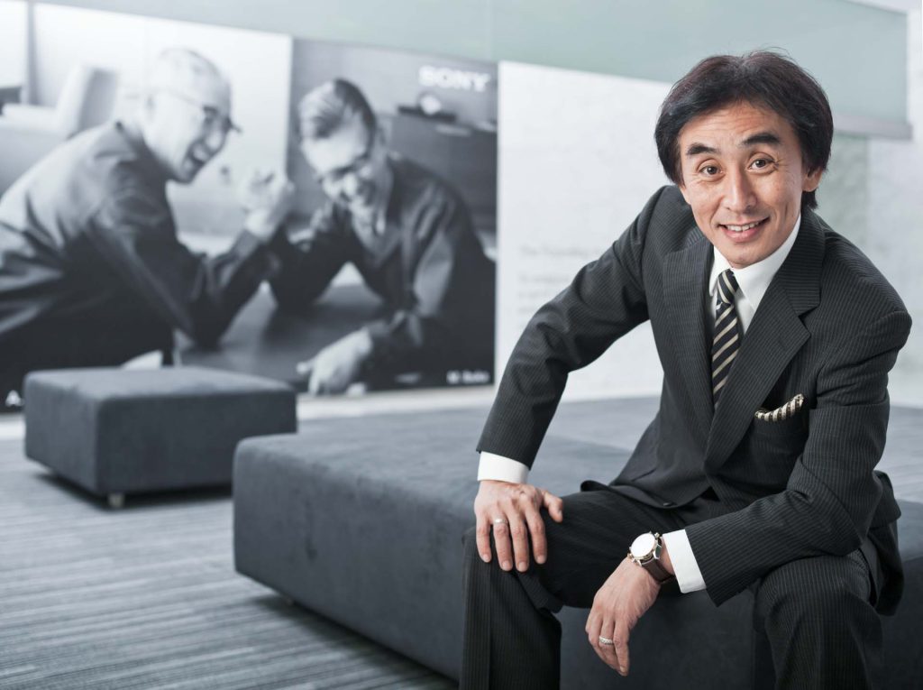 Black and white portrait of Sony's Managing Director for Asia Pacific, seated and mid-gesture in the office