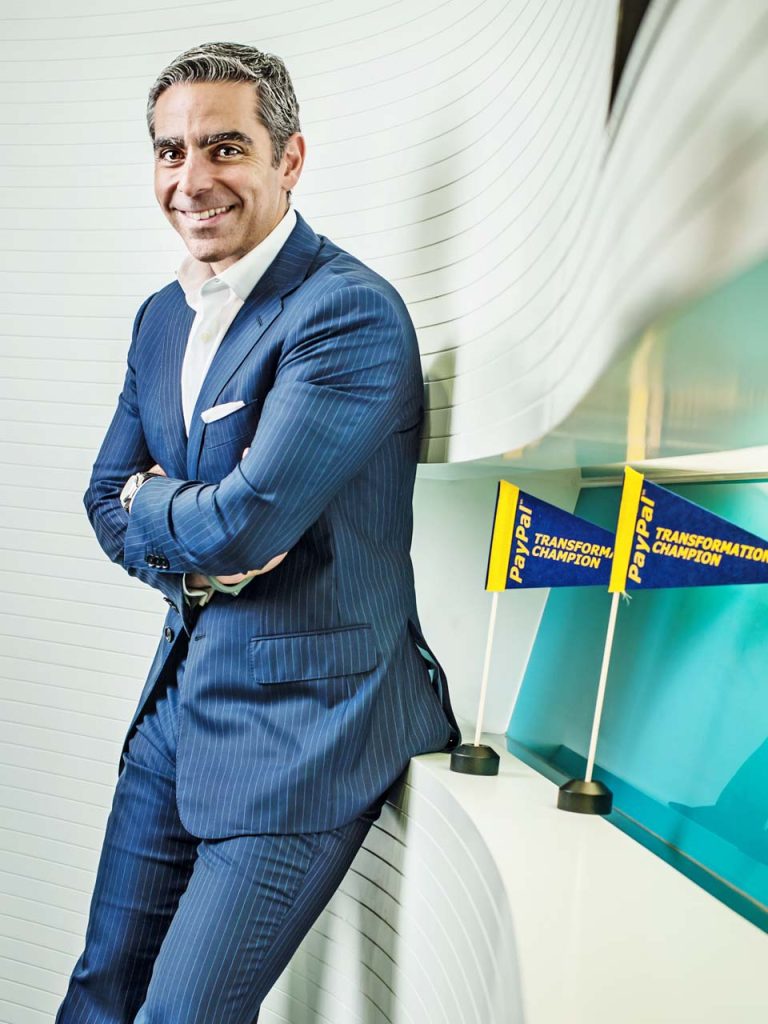 David Marcus in a blue checked suit, arms folded, photographed in front of yellow conference signage — singapore C-suite portrait photography, singapore CEO corporate photographer