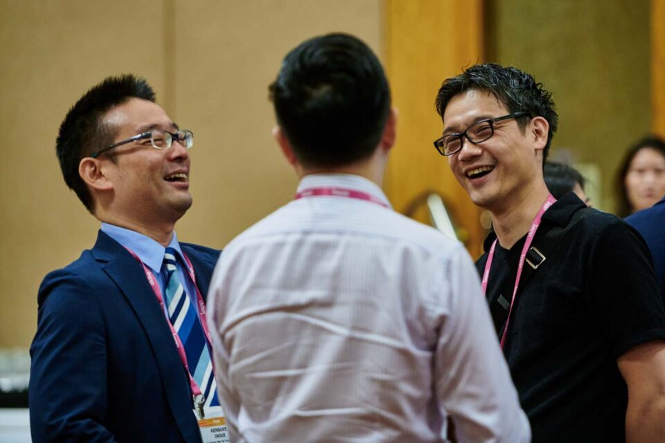 Two delegates in conversation wearing lanyards at the IAPP Asia Privacy Forum 2024 — singapore corporate events photographer, professional corporate events photography singapore
