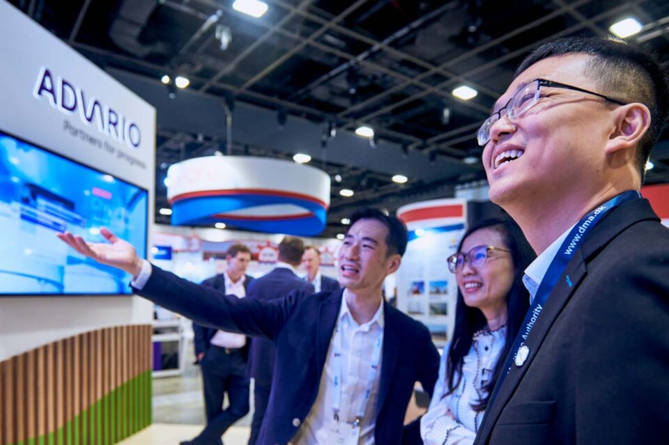 Group of delegates listening to a screen presentation at the Advario stand — singapore corporate events photographer, professional corporate events photography singapore