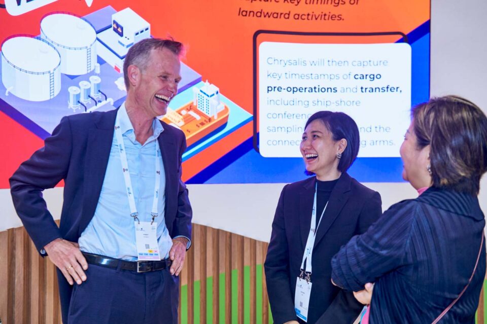 Two delegates in discussion in front of a presentation screen at Singapore Maritime Week — singapore corporate events photographer, professional corporate events photography singapore