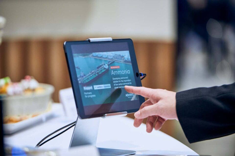 Visitor using a tablet display at the Advario stand during Singapore Maritime Week — singapore corporate events photographer, professional corporate events photography singapore
