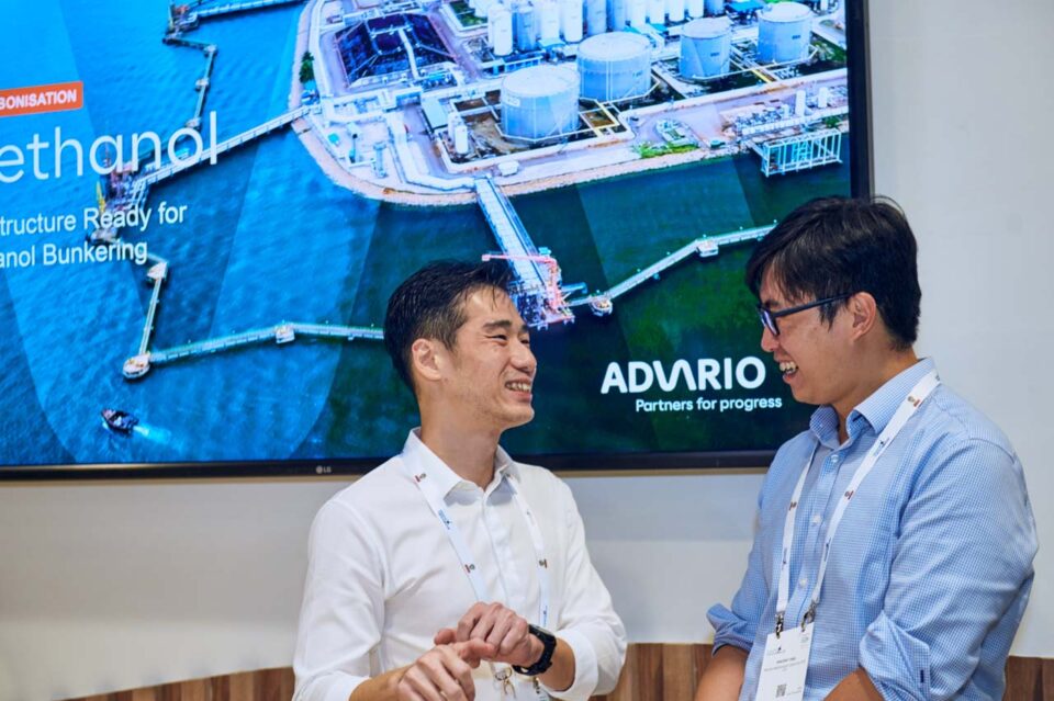 Delegate beside a vessel and methanol graphic on the stand screen at Singapore Maritime Week — singapore corporate events photographer, conference photography singapore