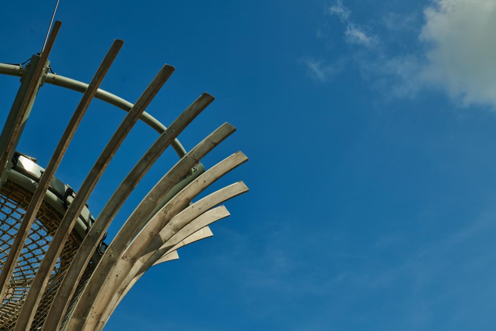 Detail of the curved play structure at the Kompan playground against a clear blue sky