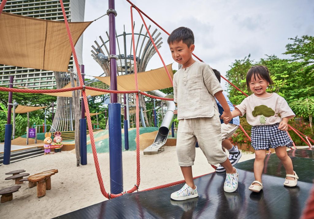 Two children playing on the red climbing structure at the Kompan playground at Gardens by the Bay — singapore commercial photographer, corporate photographer singapore