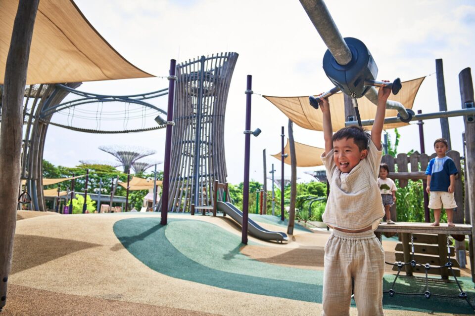Child playing beneath the tall pole structure at the Kompan playground at Gardens by the Bay — playground photographer — singapore commercial photographer