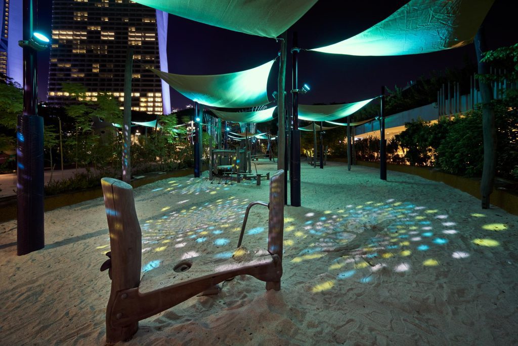 Kompan shade canopies and patterned play surface at Gardens by the Bay with city buildings behind — theatre photographer — performing arts photographer singapore