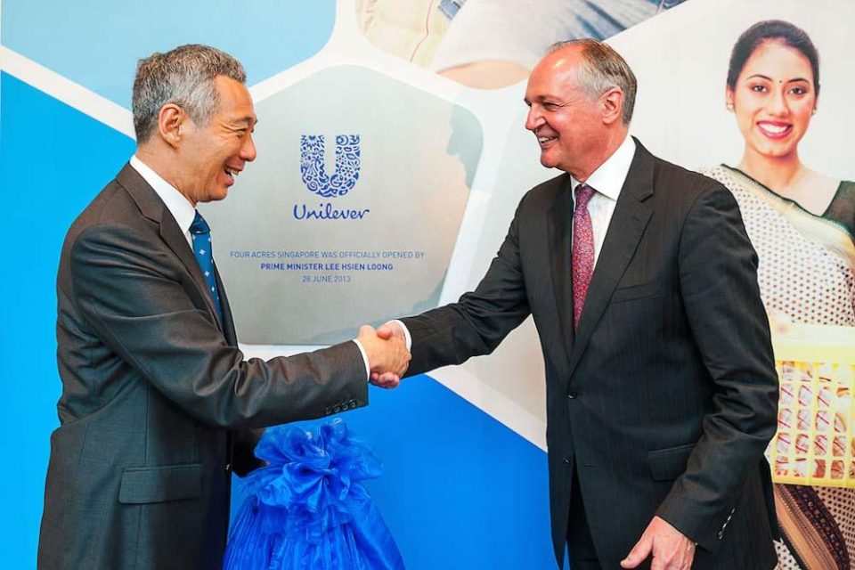 Handshake between the guest of honour and an executive on stage at the Unilever Four Acres Singapore opening — singapore corporate events photographer