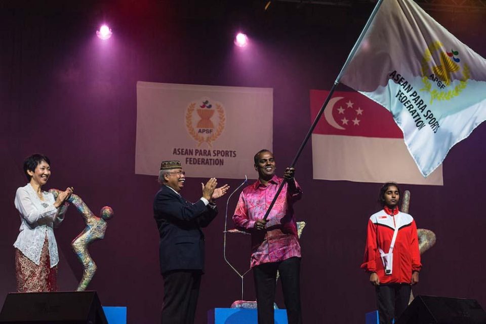 Performers in traditional costume with the Singapore flag at the 2015 ASEAN Para Games closing ceremony — singapore corporate events photographer