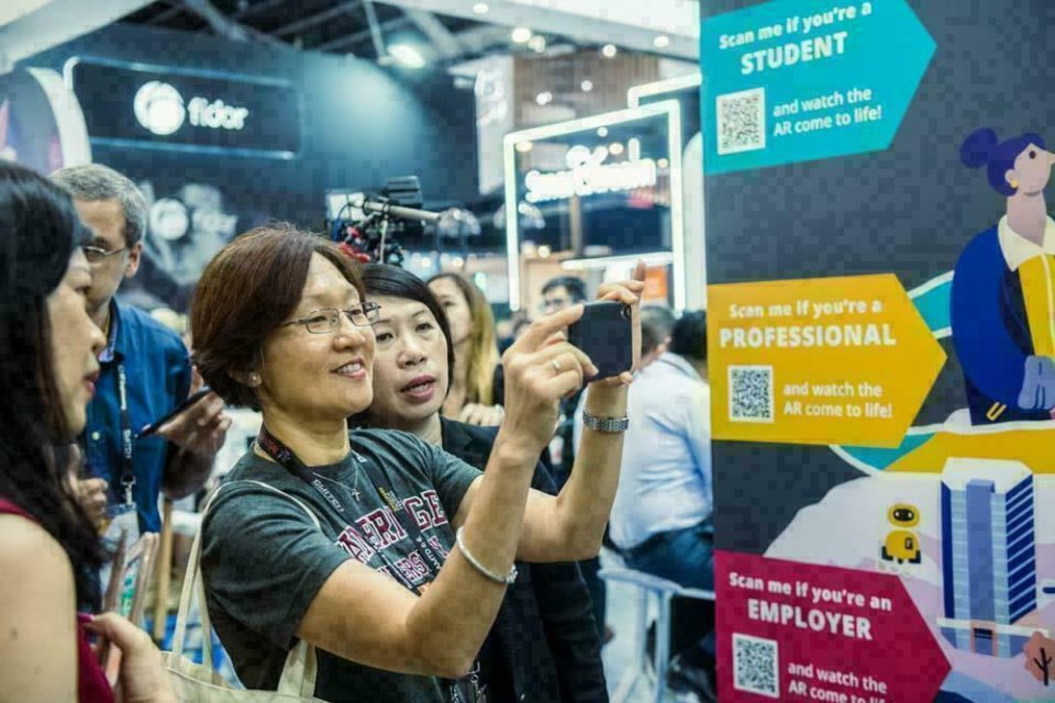 Guest photographing the stand display at the 2019 Idea Ink fintech event in Singapore — singapore corporate events photographer, professional corporate events photography singapore