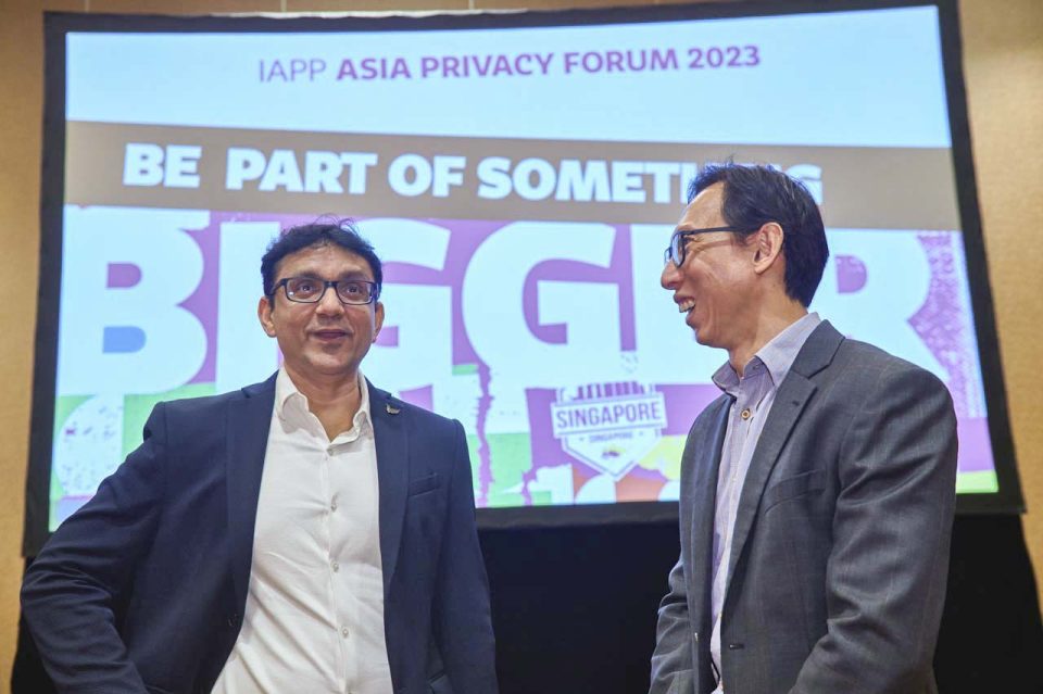 Two speakers on stage in front of a Be Part Of Something Bigger screen at the IAPP Asia Privacy Forum 2023 — singapore corporate events photographer