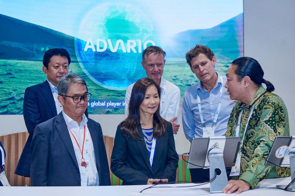 Advario team group photograph taken against a planted green backdrop at Singapore Maritime Week 2024 — company group photo singapore