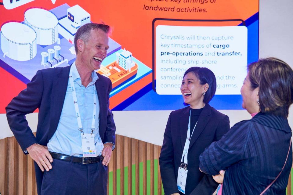 Two delegates in discussion on the exhibition floor at Singapore Maritime Week 2024 — singapore corporate events photographer, professional corporate events photography singapore