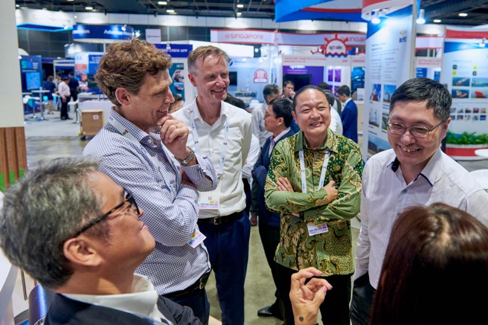 Guests in conversation at the Advario stand during Singapore Maritime Week 2024 — singapore corporate events photographer, professional corporate events photography singapore