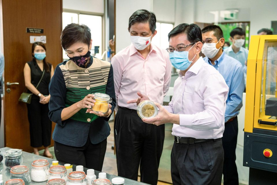 Masked guests handling a product sample at a Samwoh stand in 2020 — singapore commercial photographer, corporate photographer singapore