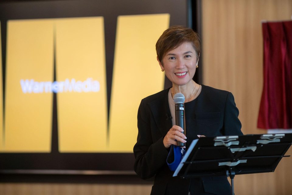 Speaker with a microphone against WarnerMedia branding at a Singapore corporate event — singapore corporate events photographer, professional corporate events photography singapore
