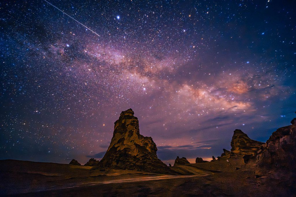 The Milky Way and a shooting star over sandstone rock formations in China's no man's land — astrophotography, professional travel landscape photography by a Singapore photographer